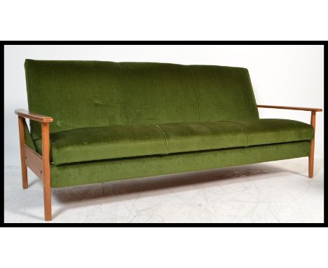 A retro 1960's Danish inspired teak wood day bed sofa. The turned legs supporting a fold down bed completed by shaped arms. M