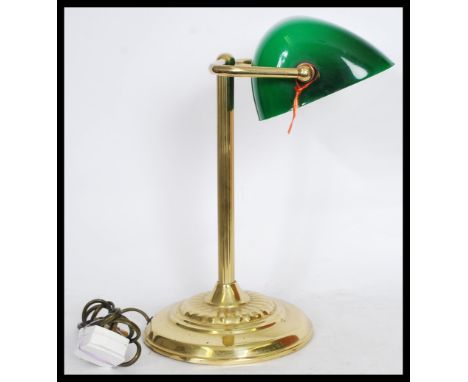 A vintage retro 20th century gilt brass bankers lamp raised on a circular base with reeded column and adjustable green glass 