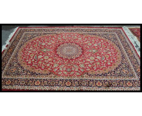 A large&nbsp; vintage Persian floor carpet Keshan rug having a red ground with geometric borders and medallions. Measures 230