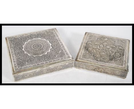 A pair of Persian Islamic silver white metal square trinket boxes with ornate embossed floral detailing, central medallions a