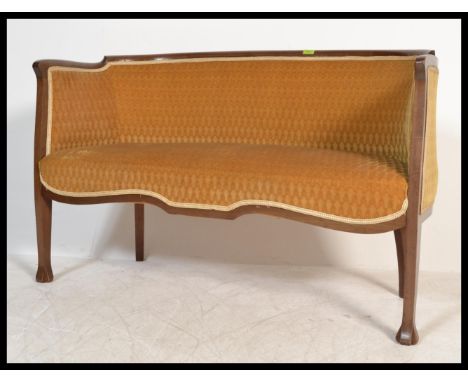 A good French early 20th century canape / conversation two seat sofa in mahogany having reeded, carved legs and shaped apron 