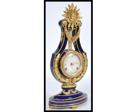 A 20th century ceramic mantle piece clock by Franklin Mint coloured cobalt with gilt garland detailing, having roman numeral 