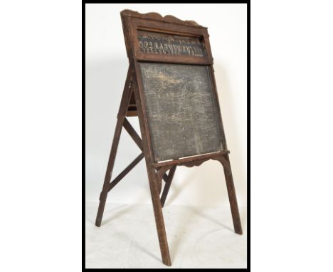 A vintage early 20th century arts &amp; crafts oak blackboard having easel back with paper alphabet letter roll.