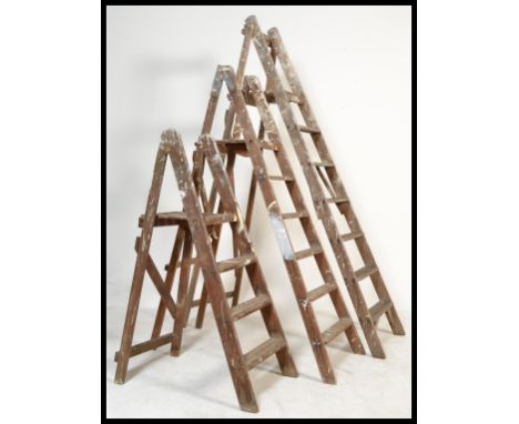 A group of three vintage 20th Century Industrial wooden step ladders, the three step ladders in graduating sizes.