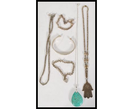 A collection of 20th century silver jewellery to include a silver engraved bangle, a hand of hamsa pendant a heart lock chain