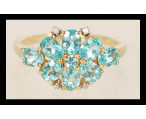 A 9ct gold ladies ring with blue stones in a prong settings including 4 inlaid diamonds, the item weighs 2.2 grams, size M.