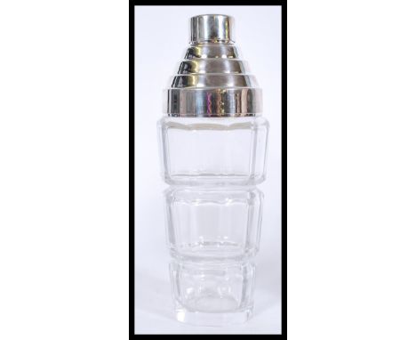 A vintage Art Deco style cocktail shaker with cut glass and a silver white metal top.