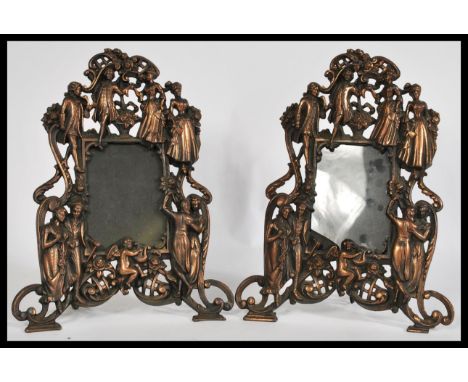 A pair of early 20th century Art Noveau cast metal mantelpiece easel mirrors having an intricate design featuring aristocrati