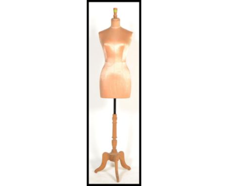 An early 20th century vintage tailors shop front ladies half dummy mannequin on a wooden a three legged triple base, the body