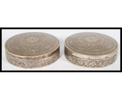 A pair of Persian Iranian silver white metal trinket boxes of circular form with Islamic geometric embossing around a central