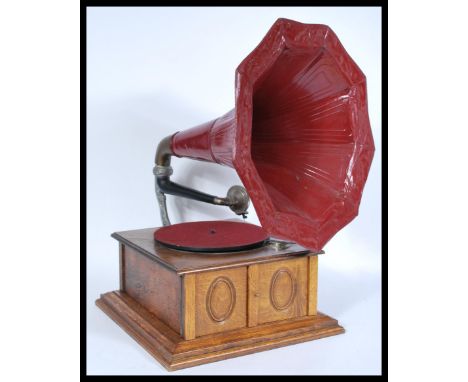 A vintage 20th century gramophone record player having an oak case with large red painted morning glory horn.&nbsp;measures: 