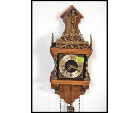 A vintage 20th century wooden wall cuckoo clock having brass drop weights. The dial having a Roman numeral chapter ring with 