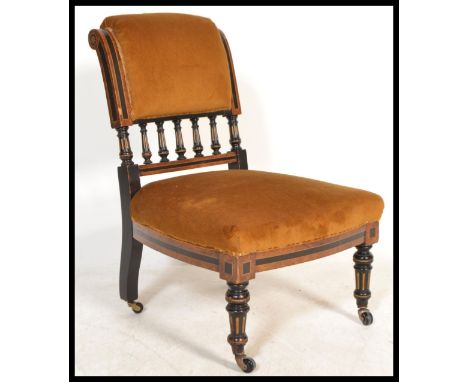 A 19th Century Aesthetic movement walnut and ebonised frame nursing chair, gallery rail to rear, over stuffed cushions raised