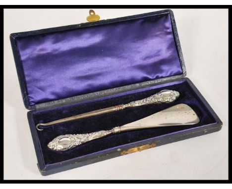 A group of silver hallmarked dressing table items to include shoe horn, button hooks, brush along with a cased shoe horn and 