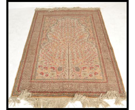 A 20th century Turkish Islamic carpet rug having a cream ground with tree of life decoration. Large central block depicting b