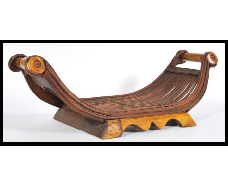 A vintage 20th century cane cheese sled having scrolled ends raised on shaped wooden supports.&nbsp;Measures: 19cm high x 55c