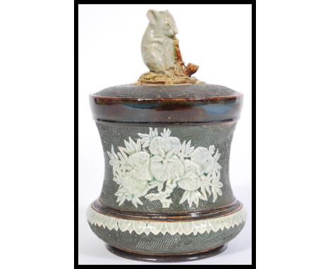 George Tinworth for Doulton Lambeth, a late 19th century lidded stoneware tobacco jar, decorated in relief, the lid with styl