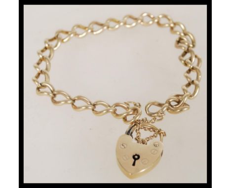 A 9ct gold 20th century bracelet with a heart padlock, safety chain and curb links. The item weighs 12.7 grams.