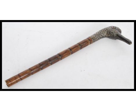 An early 19th century George III silver ladies walking stick handle in the form of a duck with glass bead eyes on a bamboo sh