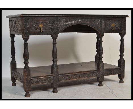 A Jacobean 19th century revival hall&nbsp; console lowboy table, heavily carved throughout, arched frieze to centre flanked b