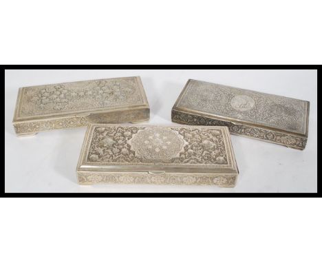 A set of three Persian Islamic silver white metal trinket boxes having embossed floral detailing to the tops and sides, one i