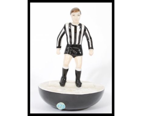 A Royal Doulton Subbuteo ceramic football figurine MCL 12 featuring a player in black and white stripped kit on black and whi