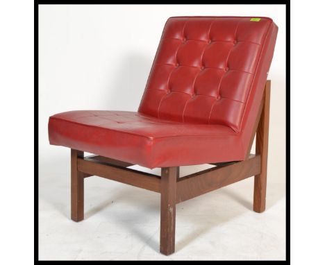 A 1970's retro vintage easy lounge chair / armchair comprising of a button backed crimson red vinyl seat cushion and back cus