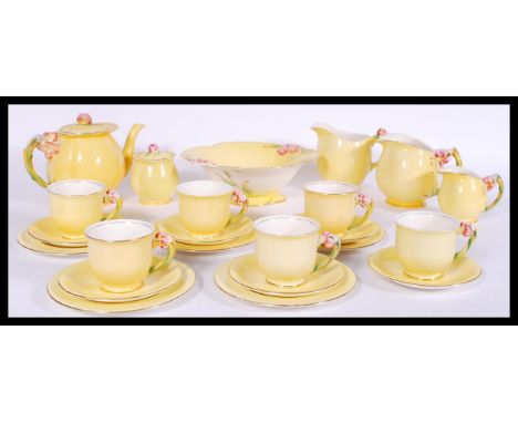 A Royal Winton art deco tea service having yellow decoration with floral handles. Stamped to bases. Consists of teapot, jug, 
