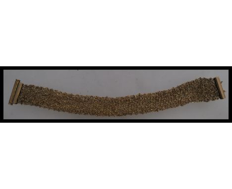 A contemporary Italian designer 9ct gold bracelet stamped 375 including a mesh linked gold band and a bar clasp. Item weight 