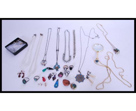 A collection of costume jewellery to include a magnifying glass pendant, a collection of agate pendant stones, an Art Deco st