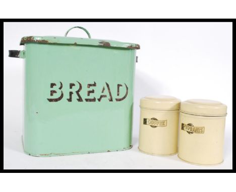 A vintage retro enamel bread bin in mint green with two enameled condiment tins reading 'coffee' and 'currants' with hinged l