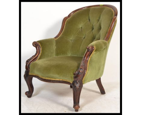 A 19th Century Victorian mahogany armchair with carved scrolling frame, cabriole legs, button back velour upholstery on casto
