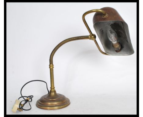 A vintage 20th century brass bankers desk lamp raised on a stepped circular base with adjustable gooseneck and swivel shade a