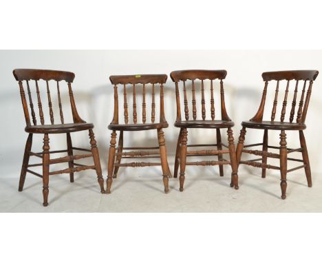 A set of four 19th century Victorian Windsor elm and beech stick back dining chairs having solid elm seats and back rests wit