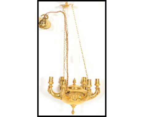 A 19th century ormolu classical chandelier modeled on a hanging oil lamp having decorative lion embossing to the arms and che