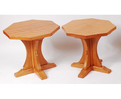 A pair of Robert 'Mouseman' Thompson of Kilburn octagonal joined adzed oak occasional tables, each on curved and notched supp