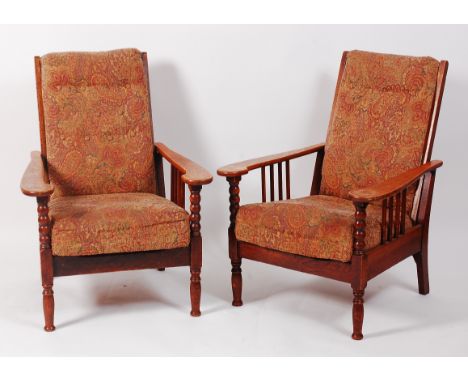 A pair of Arts & Crafts oak framed and heavy floral buttonback upholstered reclining open armchairs, in the manner of Liberty