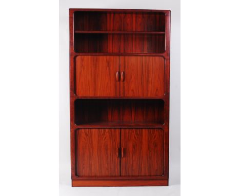 A 1970s Danish rosewood wall unit by Dyrlund, the open upper single shelf compartment over twin tambour sliding doors enclosi