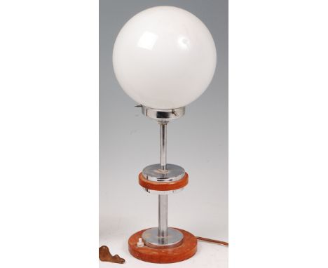 An Art Deco walnut and chrome table lamp, having a milk glass globular shade over circular central platform to conforming bas