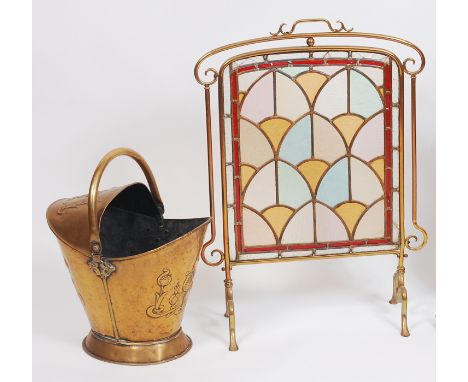 An Art Nouveau brass and coloured lead glass inset fire screen, having shaped scroll surround, with applied carry handle, 74.