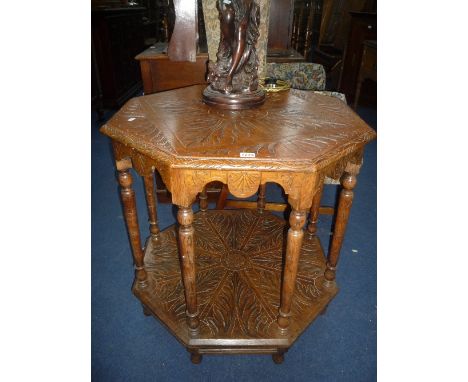 A CARVED OAK OCTAGONAL TABLE, with turned tapering supports and under shelf