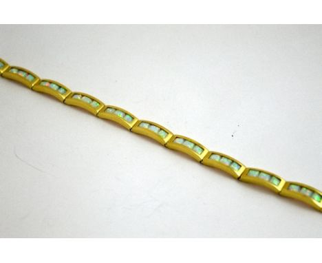 AN OPAL BRACELET, with three square synthetic opals to each link to the concealed clasp, length 18.5cm, stamped 585