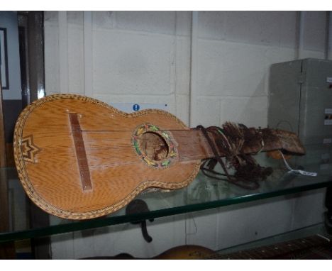 A PERUVIAN CHARANGO 10 STRING INSTRUMENT, artisan made from an Armadillo shell and inlaid top