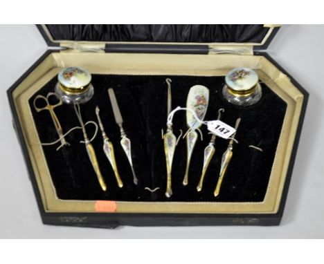 A SILVER GILT AND ENAMELLED CASED PART LADIES DRESSING TABLE SET, with files, button hooks, tweezers, buffs and lidded jars w