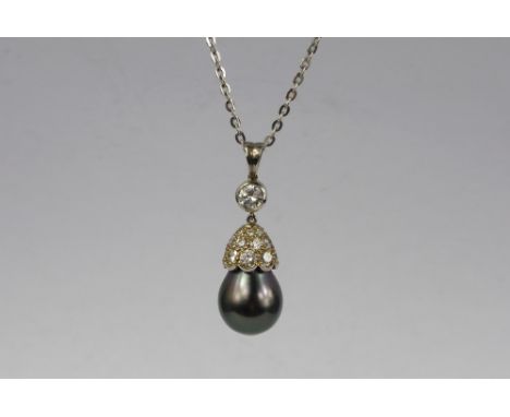 An 18 ct White Gold Tahitian Pearl and Diamond Drop Pendant. The pearl set to a diamond bud form collar suspended from solita