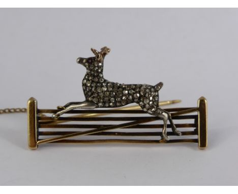An 18 ct Diamond and Ruby Deer Brooch. The brooch having a stylised deer set with ruby eyes and rose cut dias to body, the de