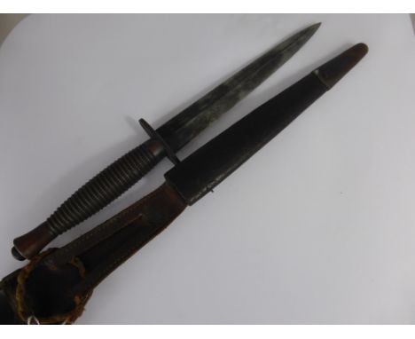 A WWII Fairbairn Sykes Commando Fighting Knife with original scabbard. The blade retains some of its original blueing, is han