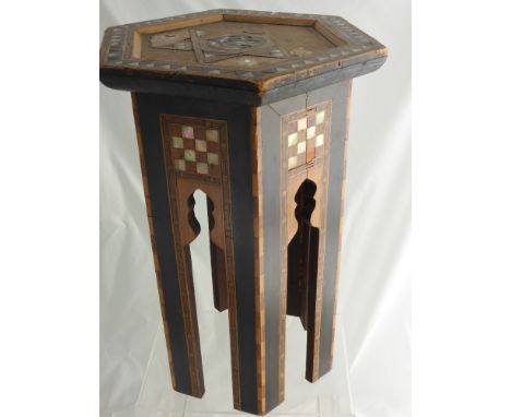 A Liberty Moorish Hexagonal Table, circa 1890, with mother of pearl inlay, ebony and stained harewood inlay, depicting a Arab