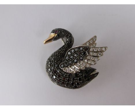 An 18ct Black and White Diamond Swan Brooch, set ruby eye black pave set diamond body with white diamond wing tips, m.m E Wol