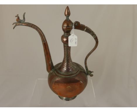 A vintage Turkish style copper coffee pot having a figure of a bird to the top of the spout and another bird to the base of t